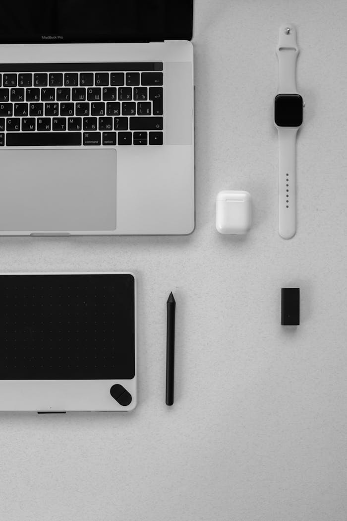 Clean and minimalist workspace arrangement featuring laptop, tablet, and smartwatch.